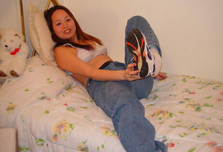 Luscious asian teen China in tight jeans uncovers small tits and puts a toy in her cunt 